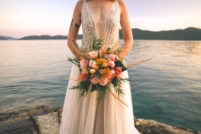 Woman in a bridal dress over on a cliff.